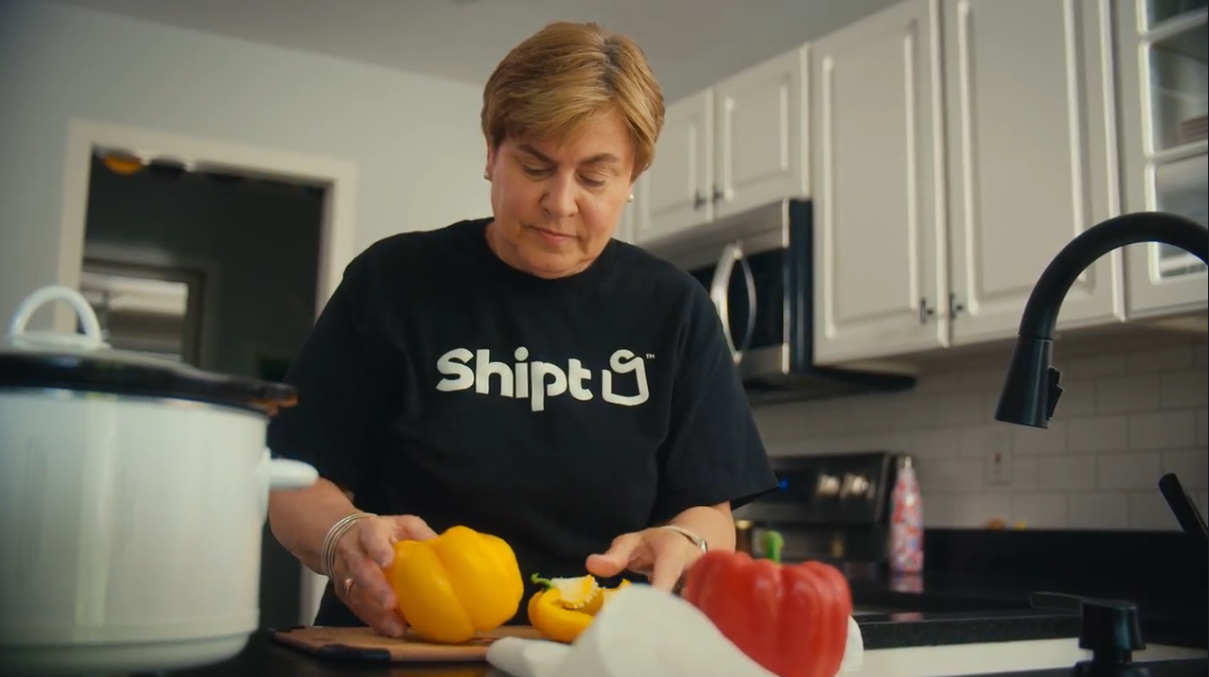 Woman in her kitchen preparing red and yellow peppers. 