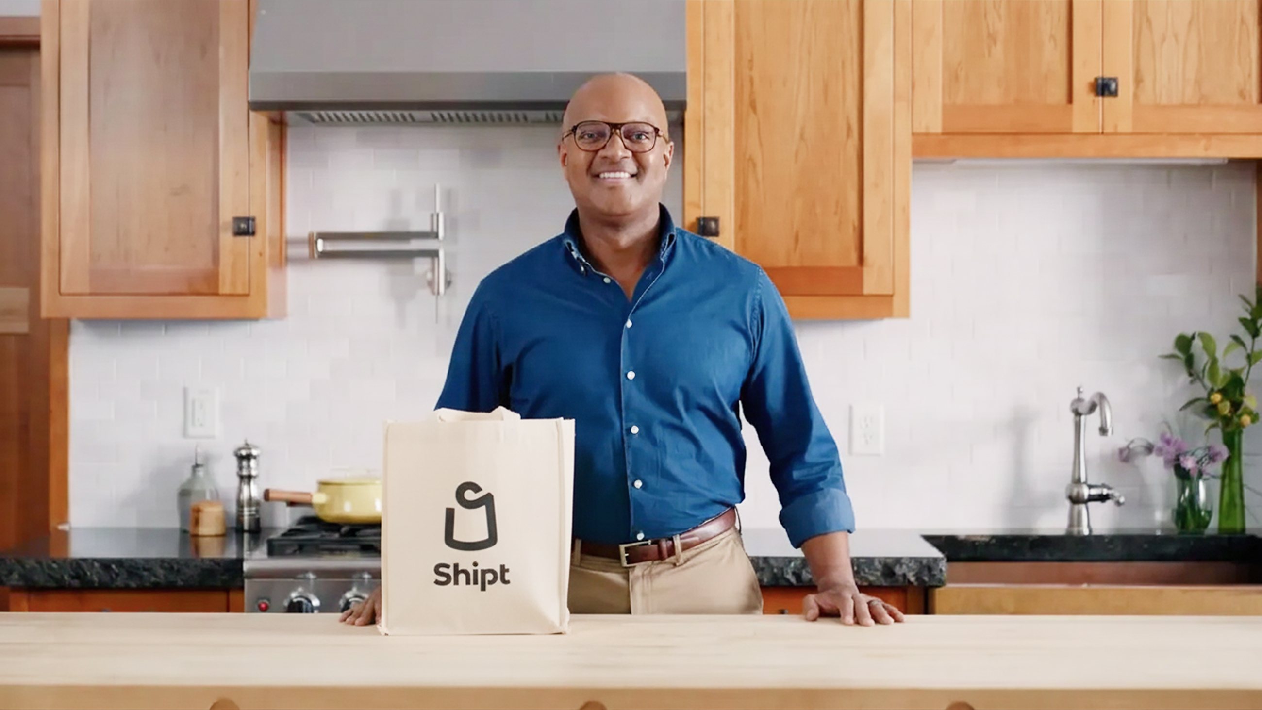 Kamau Witherspoon in a kitchen with a Shipt shopping bag